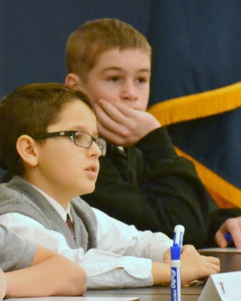 Thinking of the world beyond themselves, contestants ponder their answer in the Everest Academy National Geographic Society Geography Bee