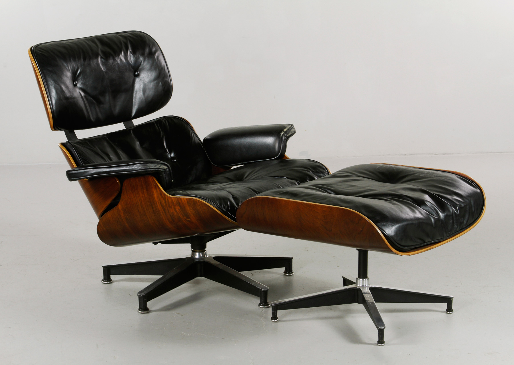 Charles and Ray Eames for Herman Miller chair and ottoman, chair with original label and original black leather, upholstery and rosewood shell