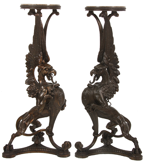 Lot 213: Pair of figural winged griffin pedestals depicting bird-like head and lion's body, 42 ½ inches tall.