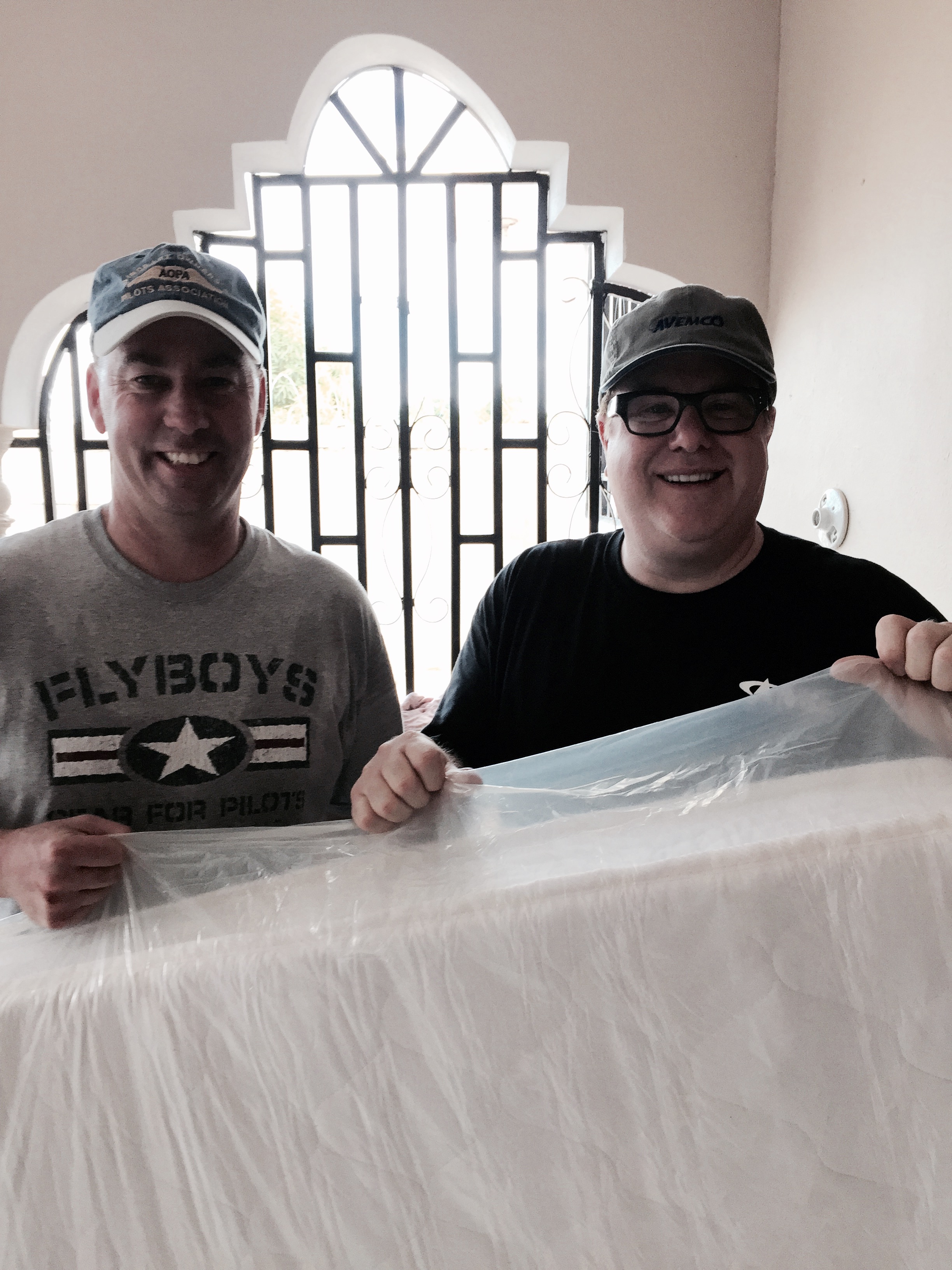 Paul Mengert and Sam Schoolfield hold up a mattress delivered to the orphanage.
