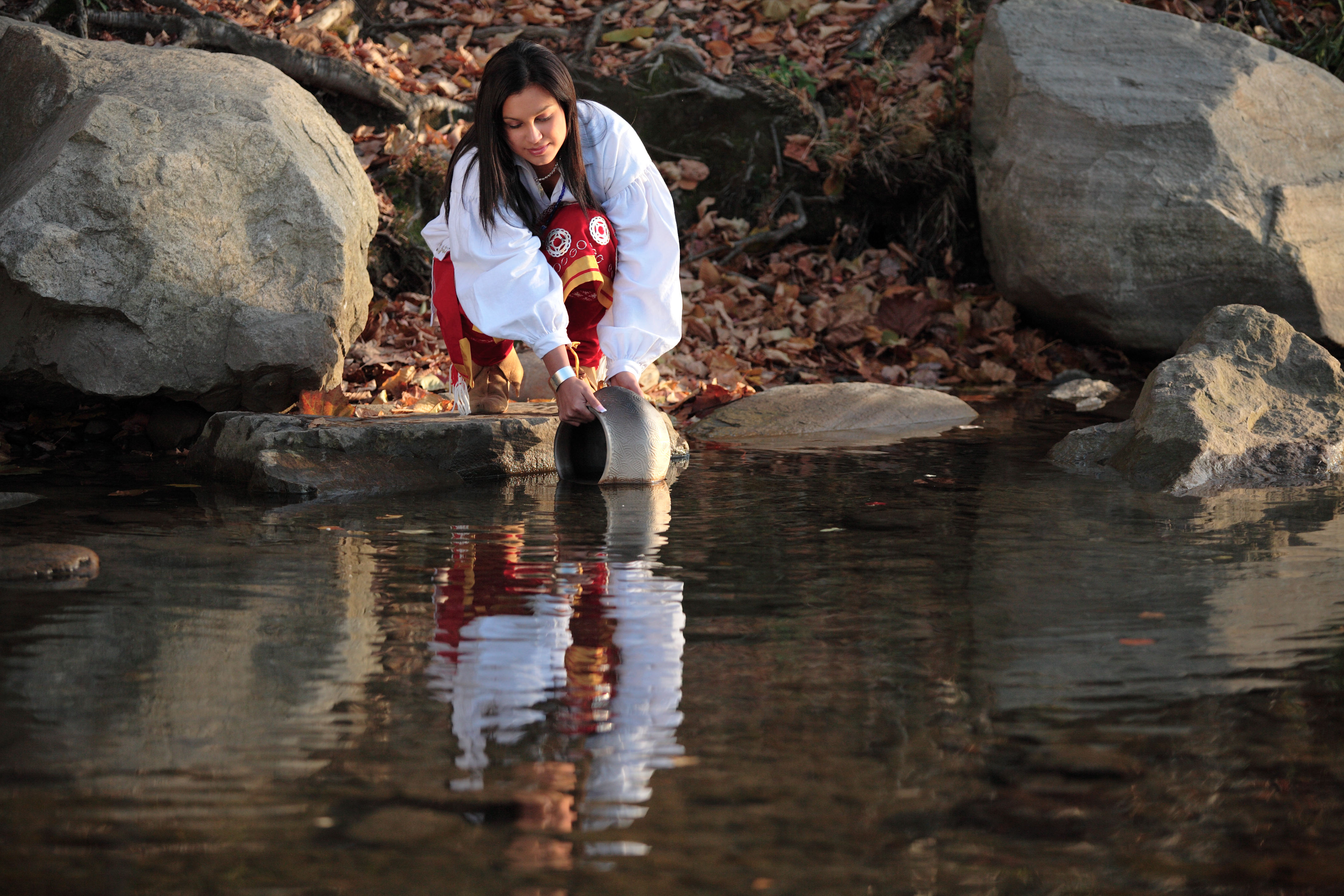 Kara Martin, Eastern Band of Cherokee Indians citizen, scoops water from the Oconaluftee River.
