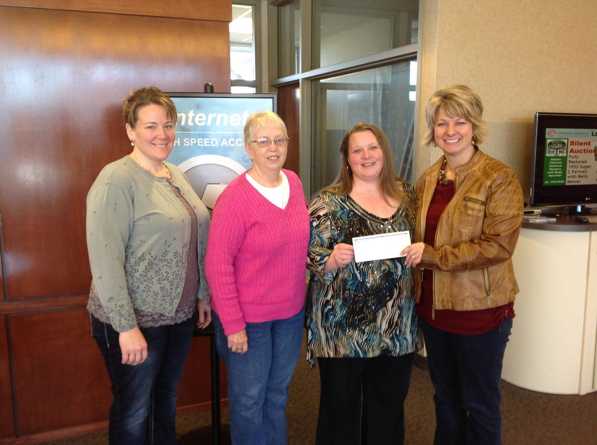 WCCTA representative Marcie Boerner presents check to Candy Bilstad, Colleen Goodwin and Judy Harvey