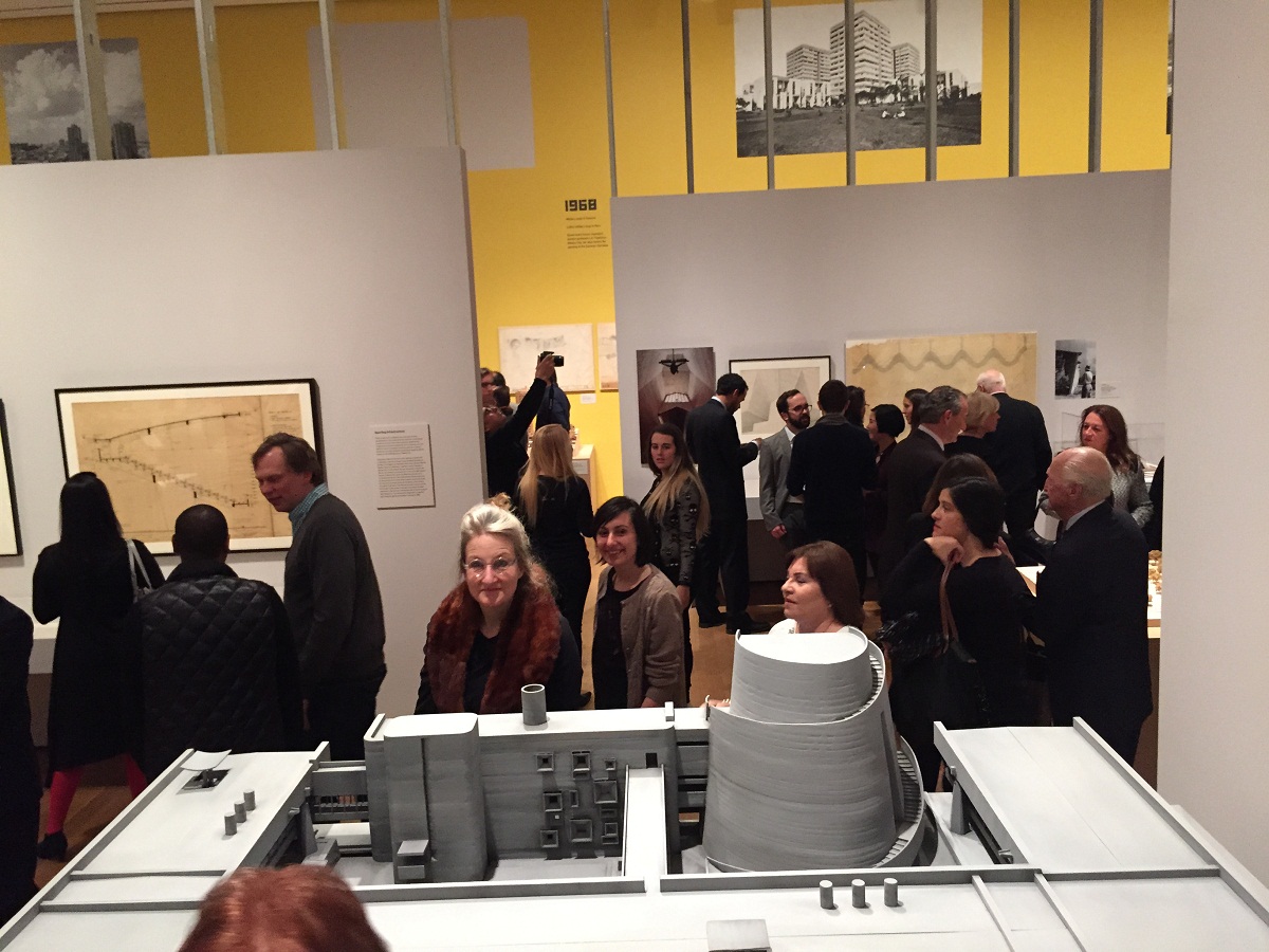 Museum-goers peruse architectural model