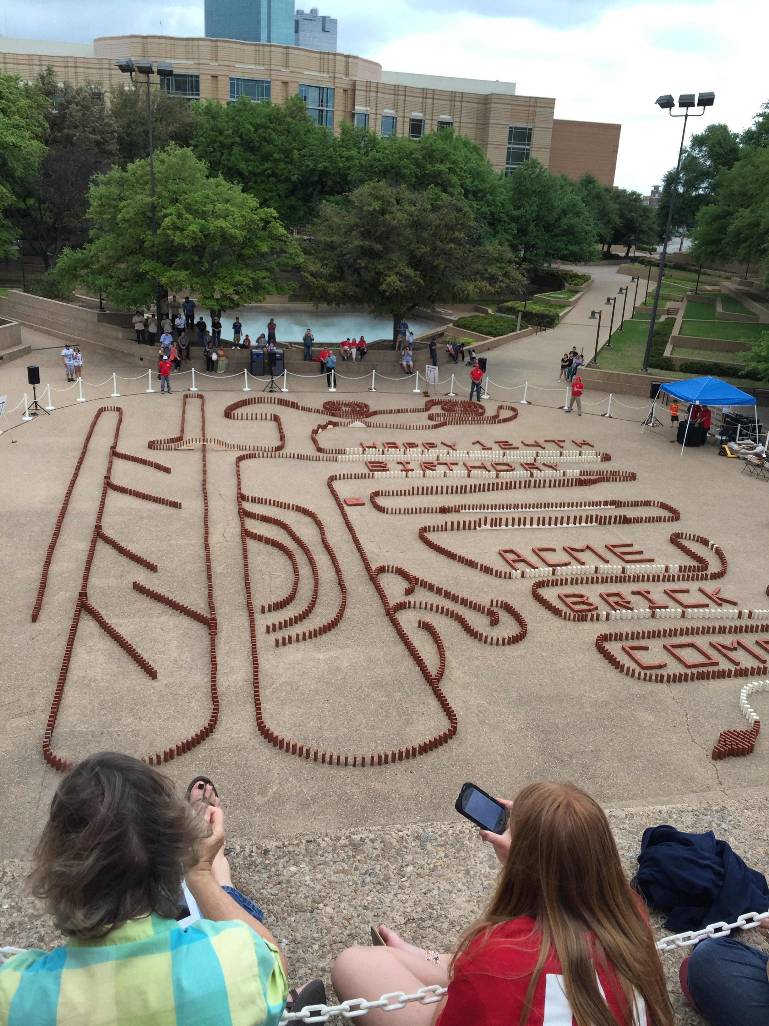 The Acme Brick 124th birthday brick topple just before the first brick falls.