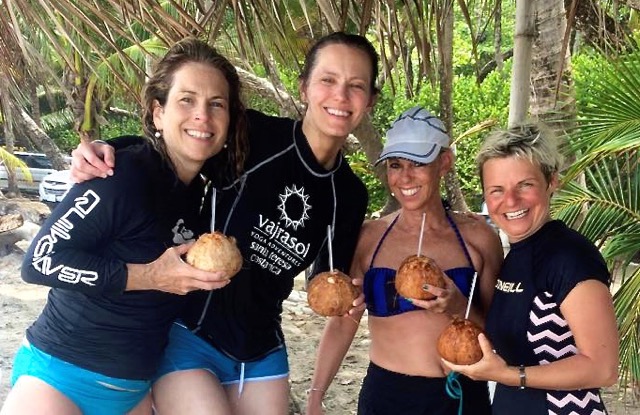 New friends on retreat enjoy a coconut drink after surfing.