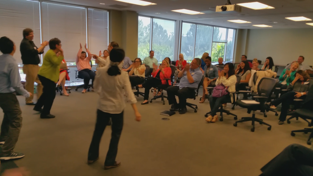 Participants laugh during a follow-the-leader exercise at a recent Advantage Improv training for a Fortune 1000 client.