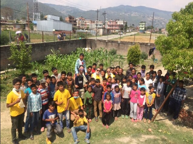 Some 40 children pose for a photo inside their orphanage near Kathmandu, Nepal, where they sang songs for Scientology Volunteer Ministers delivering food and toys as part of their relief mission.