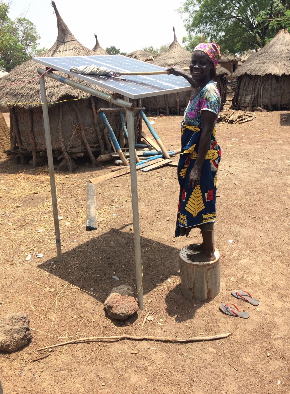 Aishetu, who runs the solar business in Tacpuli, cleans the solar panels. These panels provide energy to the charging station created by the Saha Global and Next Step Living partnership.