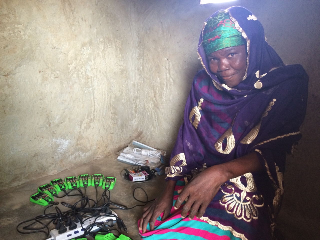 Zelia, the solar entrepreneur in Djelo, shows how she operates one of the battery-charging stations through Saha Global and Next Step Living.