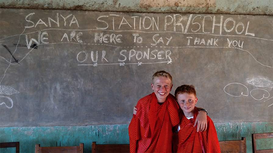 Sam and Reid Vaughan receive a chalkboard "thank you" at Sanya School