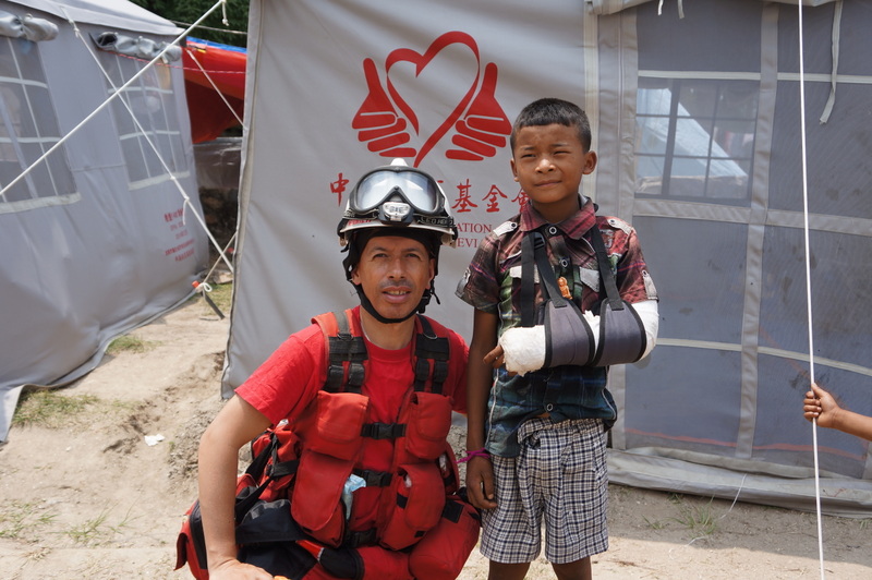 Rescue team member and Nepal child with arm in cast.