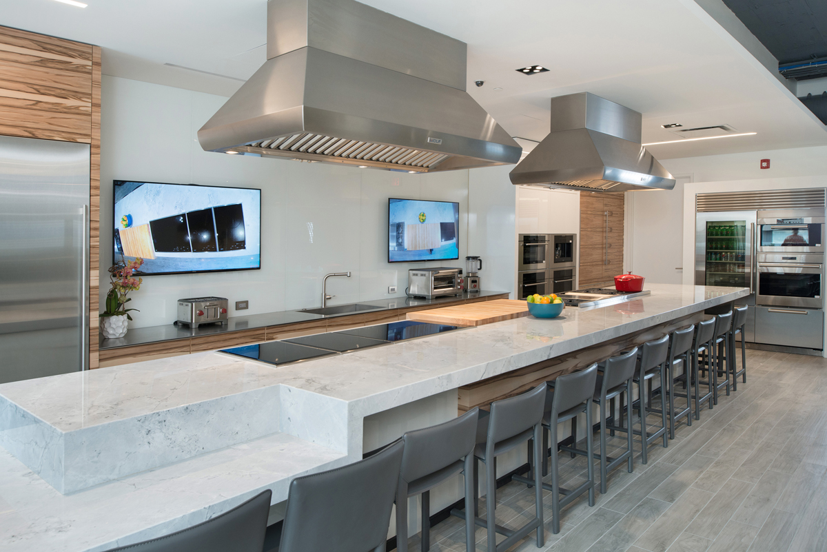 The Arch11-designed interactive gourmet demonstration kitchen for the new Roth Living showroom features a 21-foot-long, solid-surface island that seats up to 20 people (photo: Matt Kocourek).