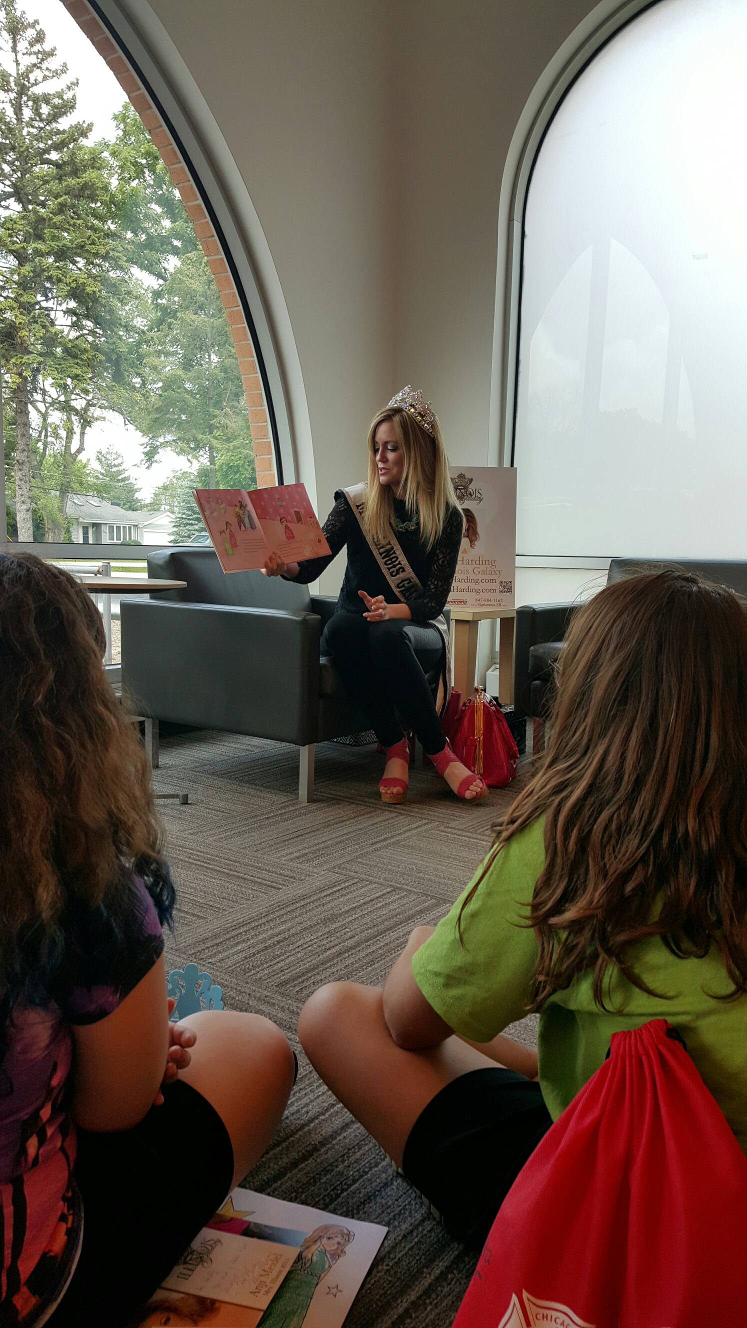 Kaili Harding, Ms. Illinois Galaxy 2015, reads a book to a group of children. Harding is also the president of the Schaumburg Business Association.