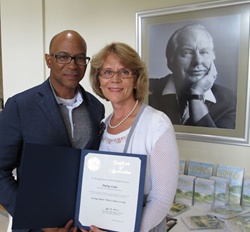 Sacramento Vice Mayor Allen Warren presents Scientologist Patty Cota with a certificate of appreciation for her volunteer work.