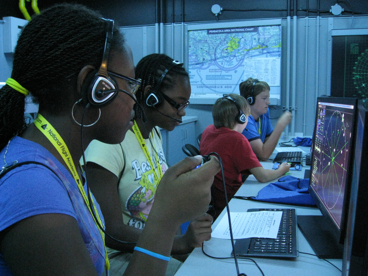 Students participate in a session on the National Flight Academy's state-of-the-art simulated aircraft carrier, Ambition.