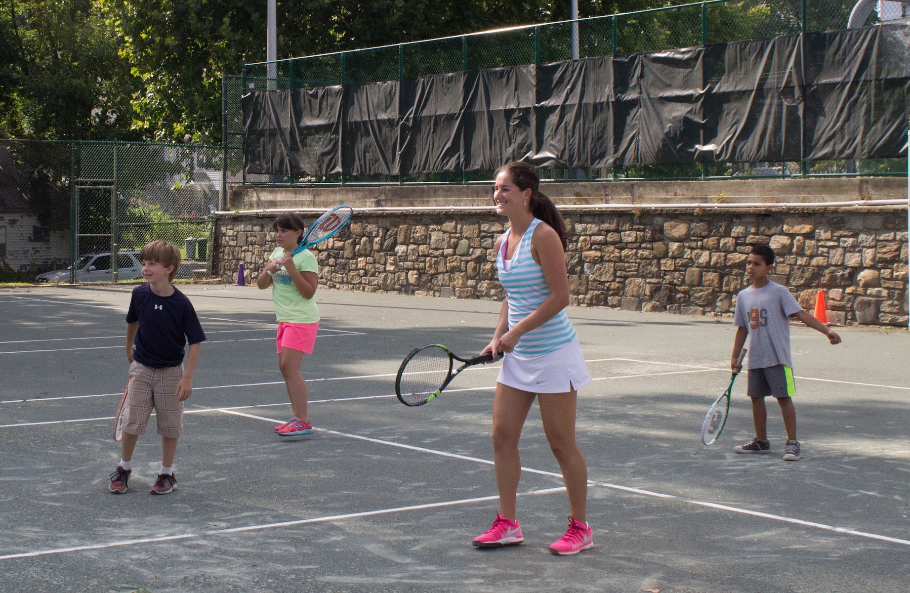 Jamie Loeb instructs young tennis players from the Ossining Day Camp program on the Nelson Park Tennis Courts.