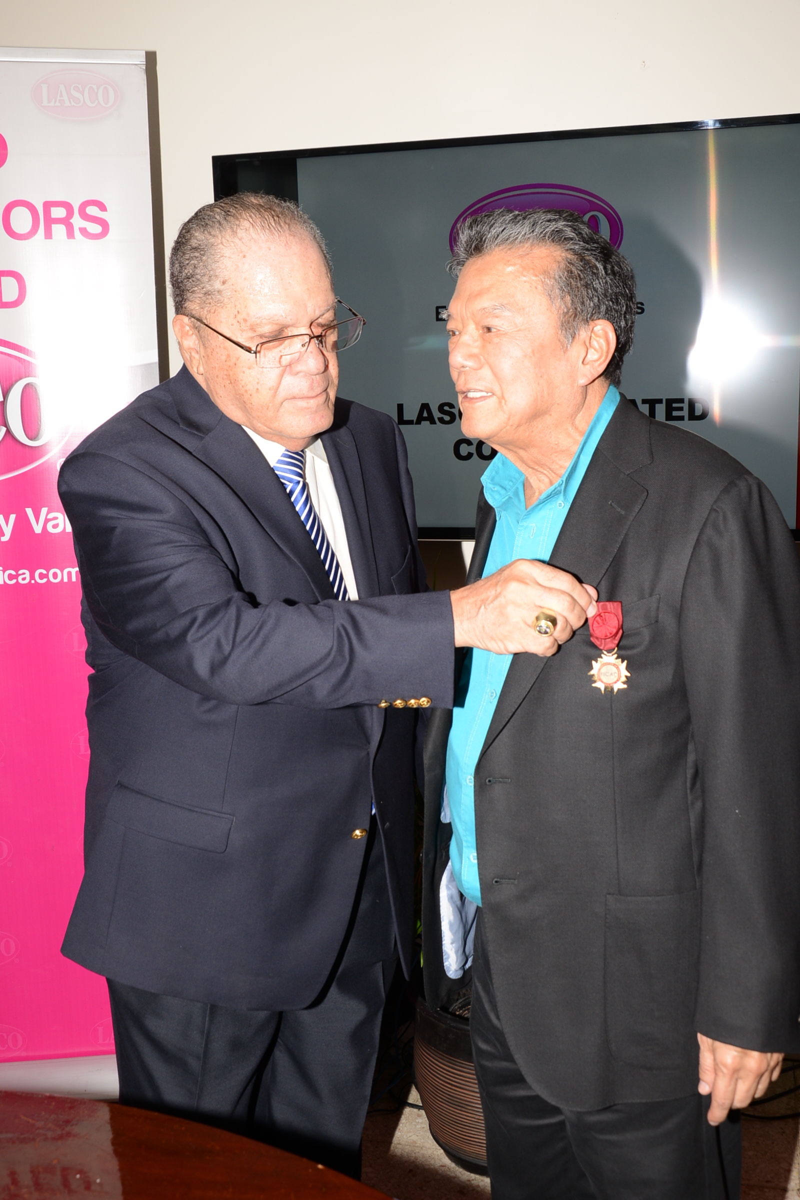 Dr. the Hon. Arnold Foote (left), President of The World Federation of Consuls confers the International Federation of Consular Associations (FICAC) Medal of Distinction on the Hon. Lascelles Chin, Fo