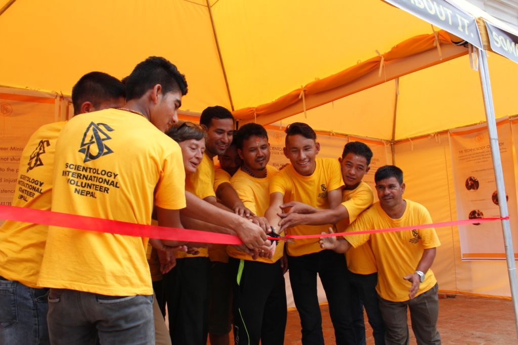 Cutting the ribbon of the new Volunteer Ministers tent in Kathmandu, the Scientology Goodwill Tour leader is joined by recent graduates trained at the new Volunteer Ministers Nepal headquarters.