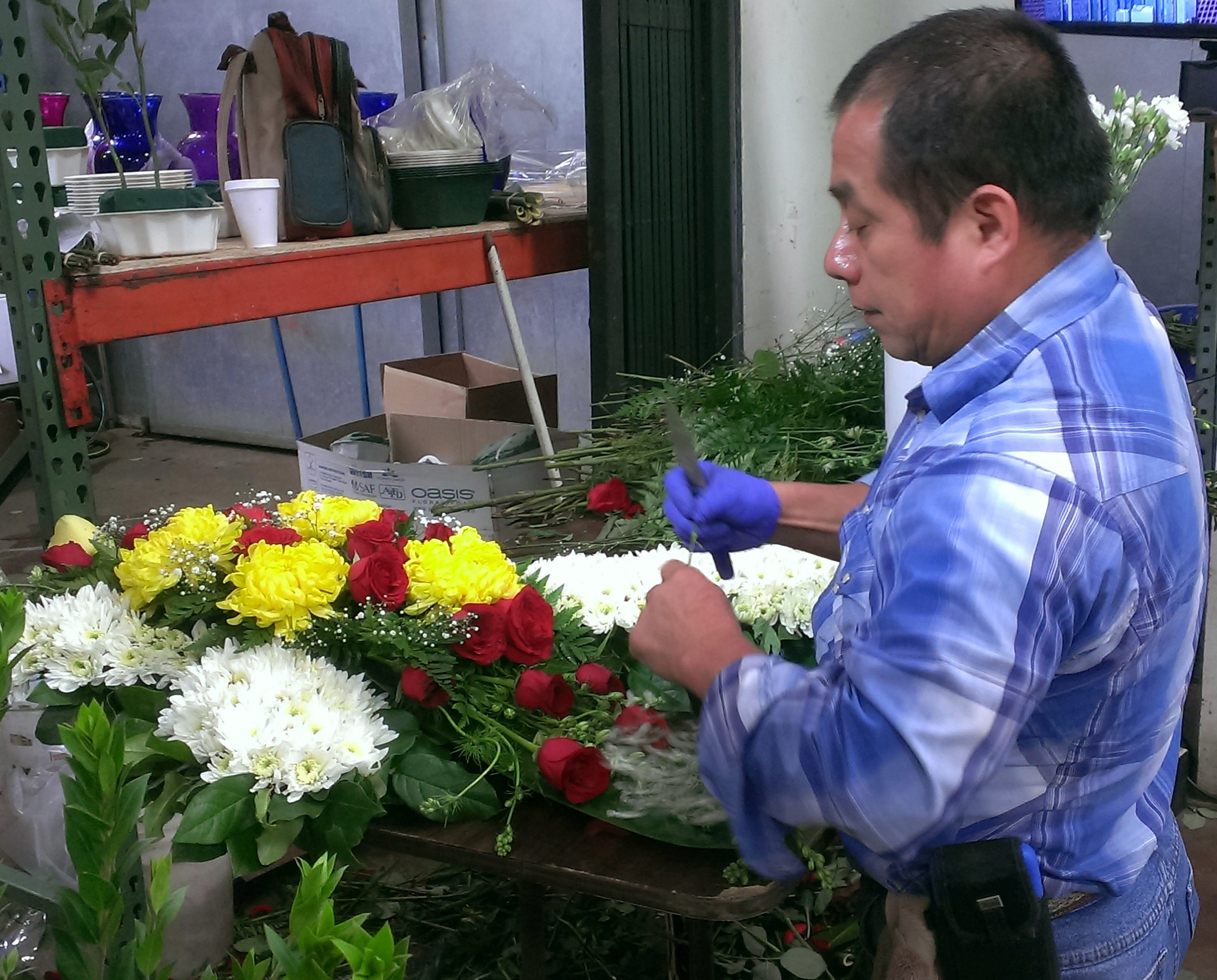 Dad Saul Jimenez recently retired from the business, creates a fresh flower funeral cross.