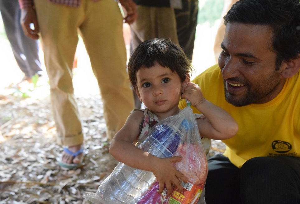 A little girl carries a food pack almost bigger than she is. Lead Volunteer Minister Binod Sharma met her while he and his team distributed food and water to families left homeless.