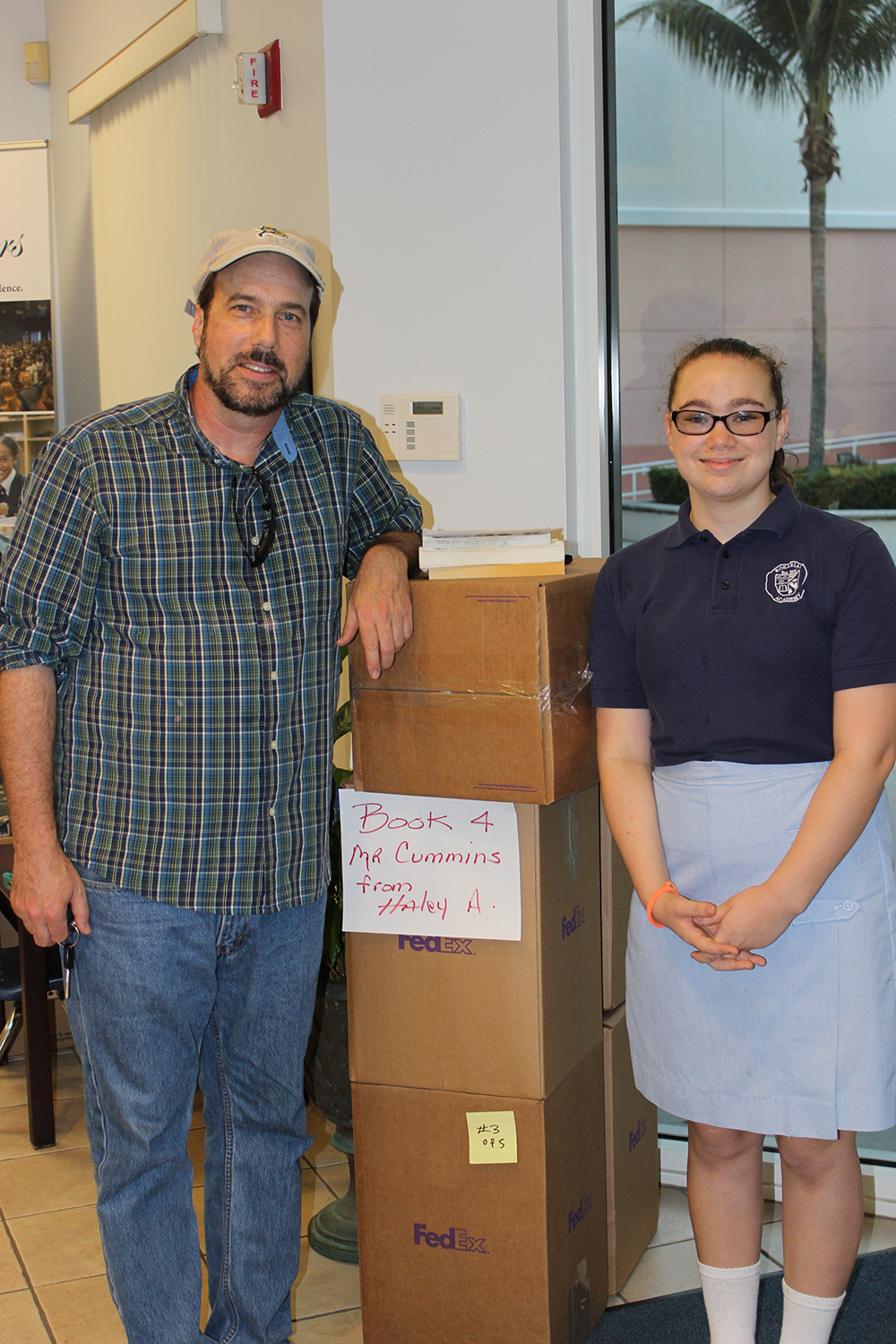Jim Cummings and Hailey Albergo with books for students in Kenya