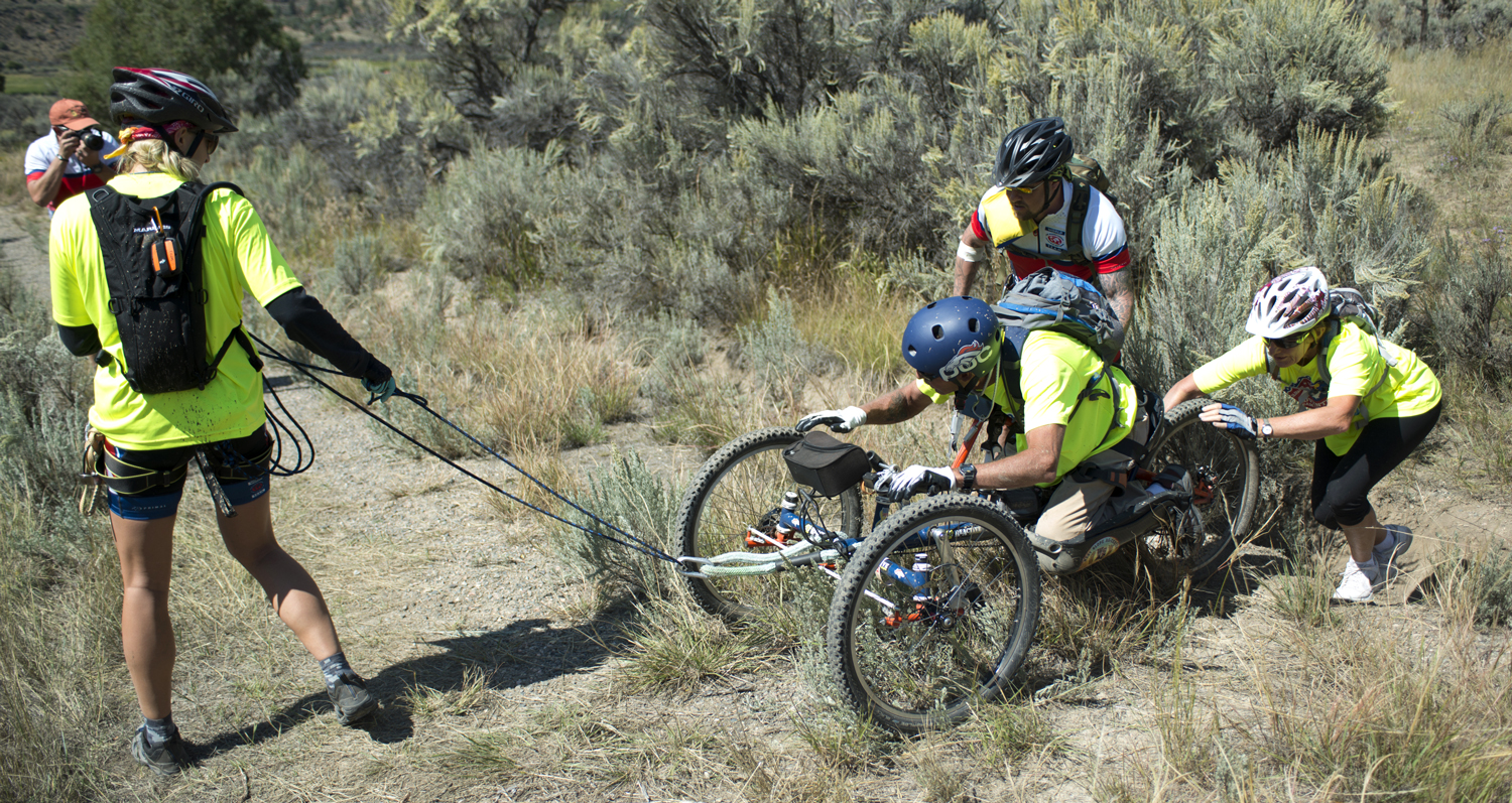 A team at the 2014 Adventure Team Challenge works together to climb a hill. Photograph by Brian Gliba.