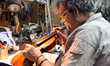 Amnon Weinstein restoring a violin, photo courtesy of Debra Yasinow and the Jewish Federation of Cleveland