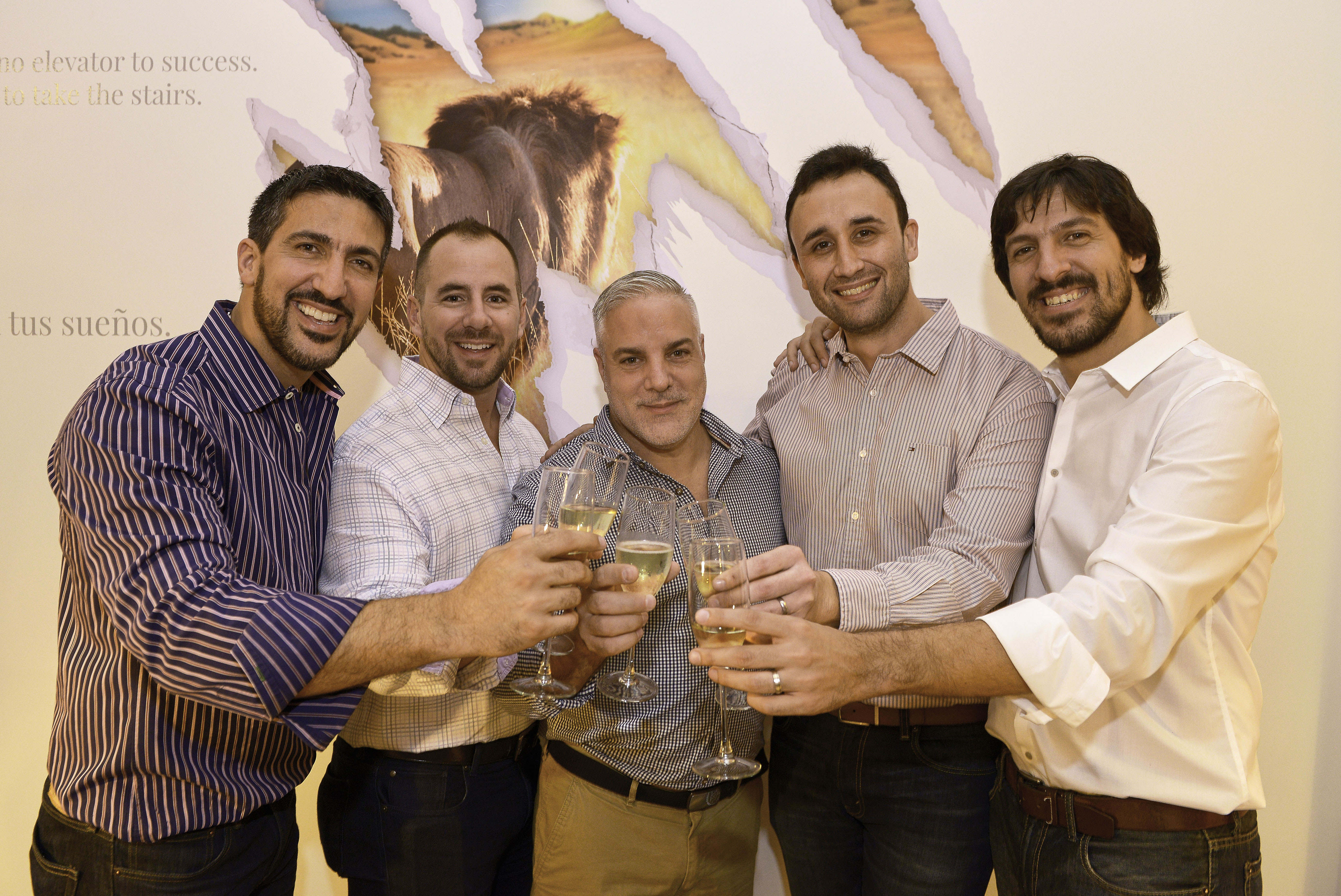 Lion Agency executives toasting to the acquisition of Arc+Arrow at an open house event held at the Lion Agency offices on September 17, 2015.