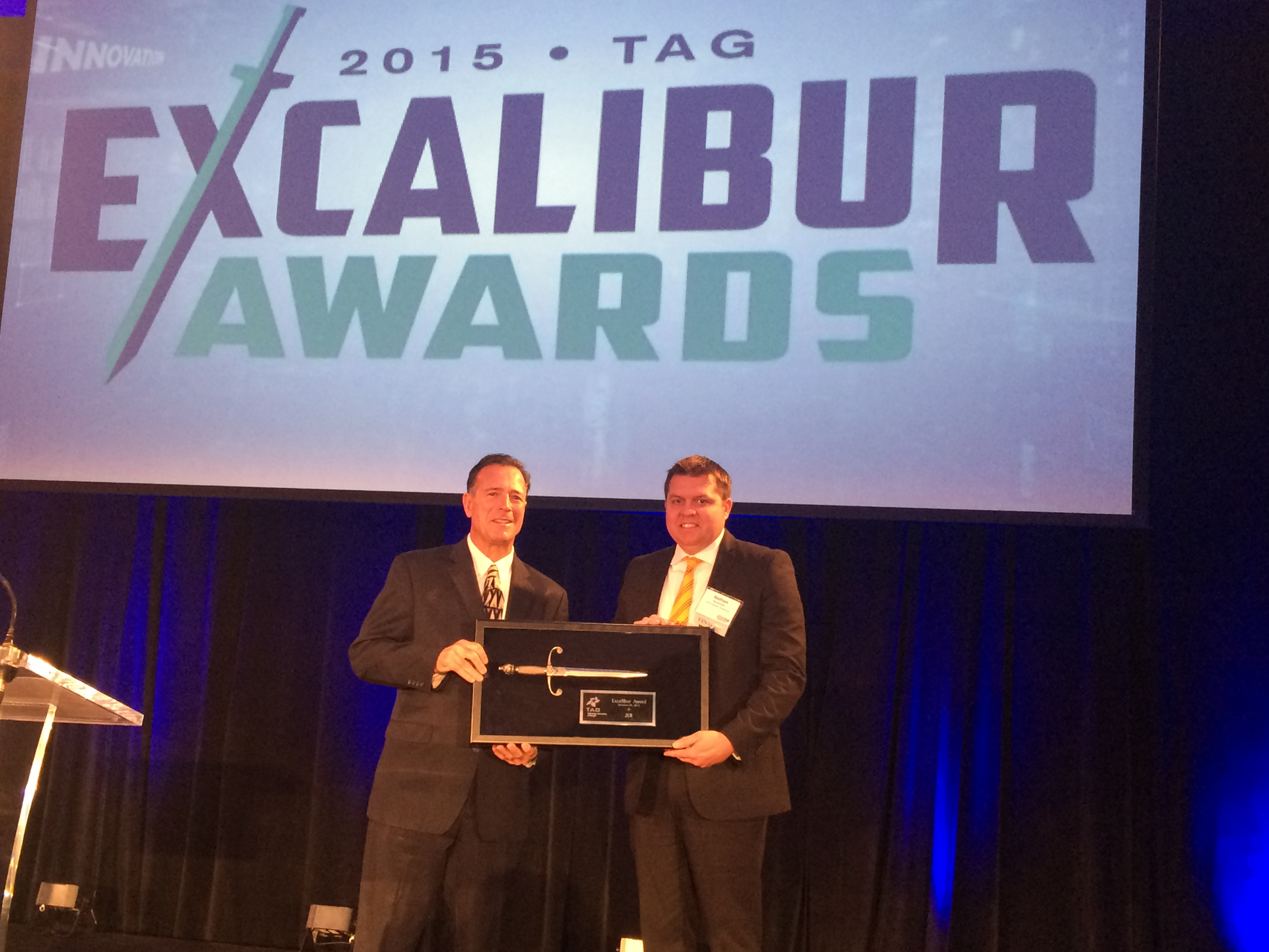 Nathan Burnham, JCB North America IT Director, accepts the TAG Excalibur Award from Tino Mantella, President & CEO of TAG.