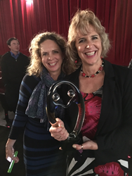 Kris Warner, executive assistant, and Faye Oney, marketing coordinator accept the award for Pearl
