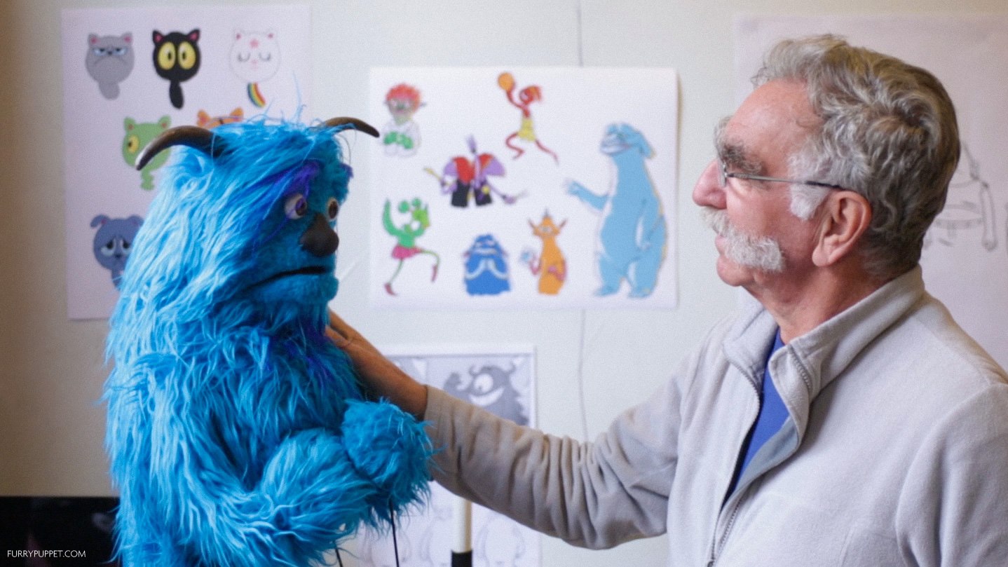 A puppet designer inspects his new creation
