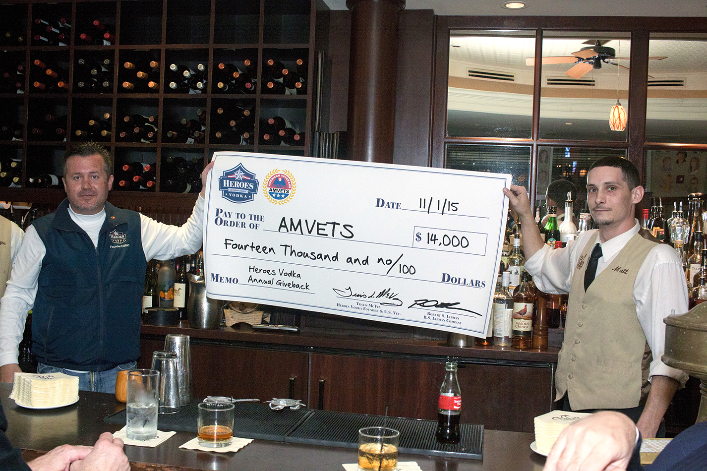 Travis McVey presents a $14,000 giveback check to staff members and Heroes Vodka fans at The Palm Restaurant & Bar.
