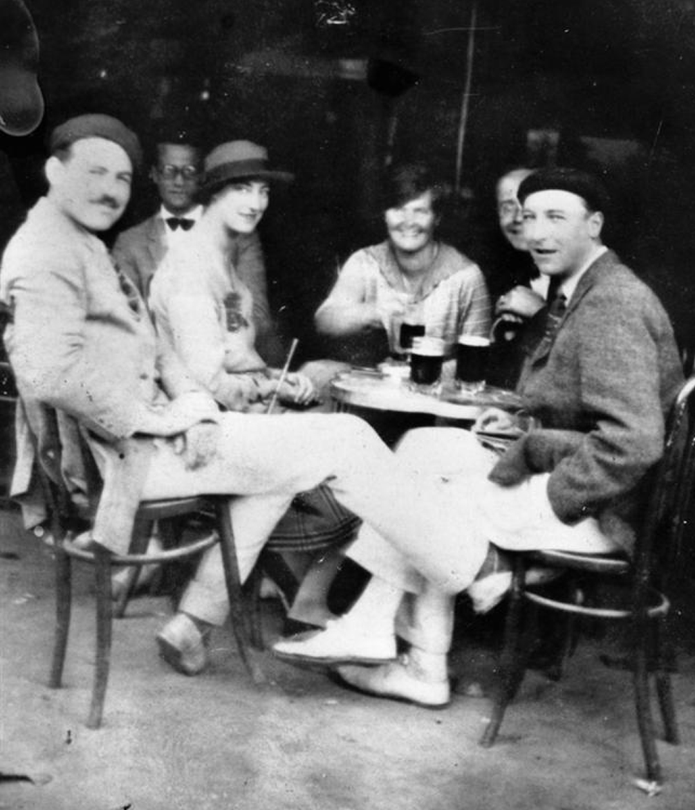 Famous American ex-pat and author Ernest Hemingway (left) exchanges ideas with friends at a European cafe in 1925.