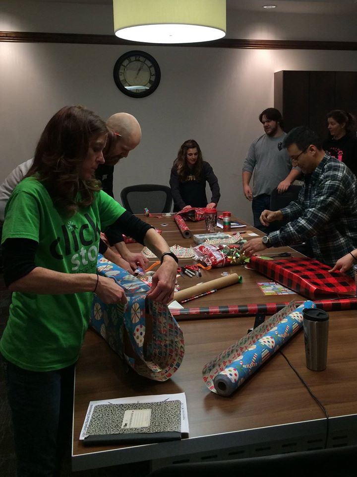 Clickstop employees help wrap Christmas presents for 19 area families.
