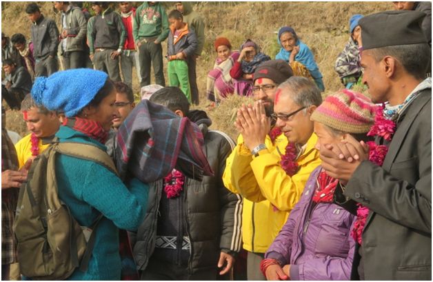 Volunteer Ministers (in yellow) present winter clothing and warm blankets to villagers in Aaru Pokhari, where nearly every one of the 240 households and the village schools suffered severe earthquake