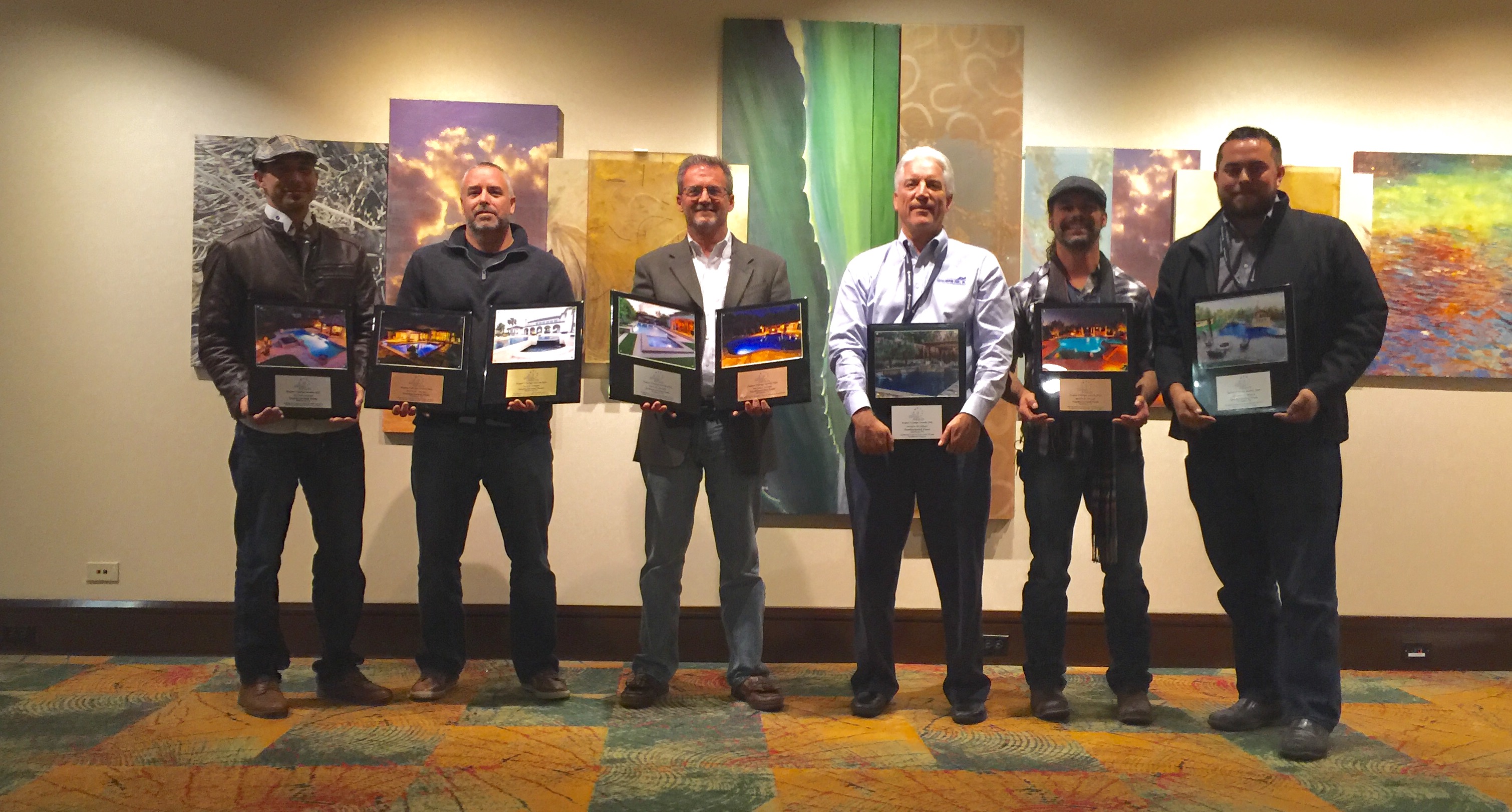 The Southernwind Pools Design Team holds their 8 winning award plaques.