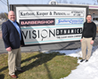 Scott Krug and Charlie Collins stand in front of the Vision Dynamics sign (Vision Dynamics was just acquired by New England Low Vision and Blindness)