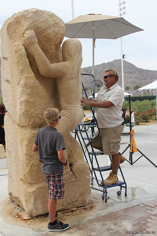 Artists David and Chris Falossi sculpting "Spirit Climb" from a 5-ton limestone block.