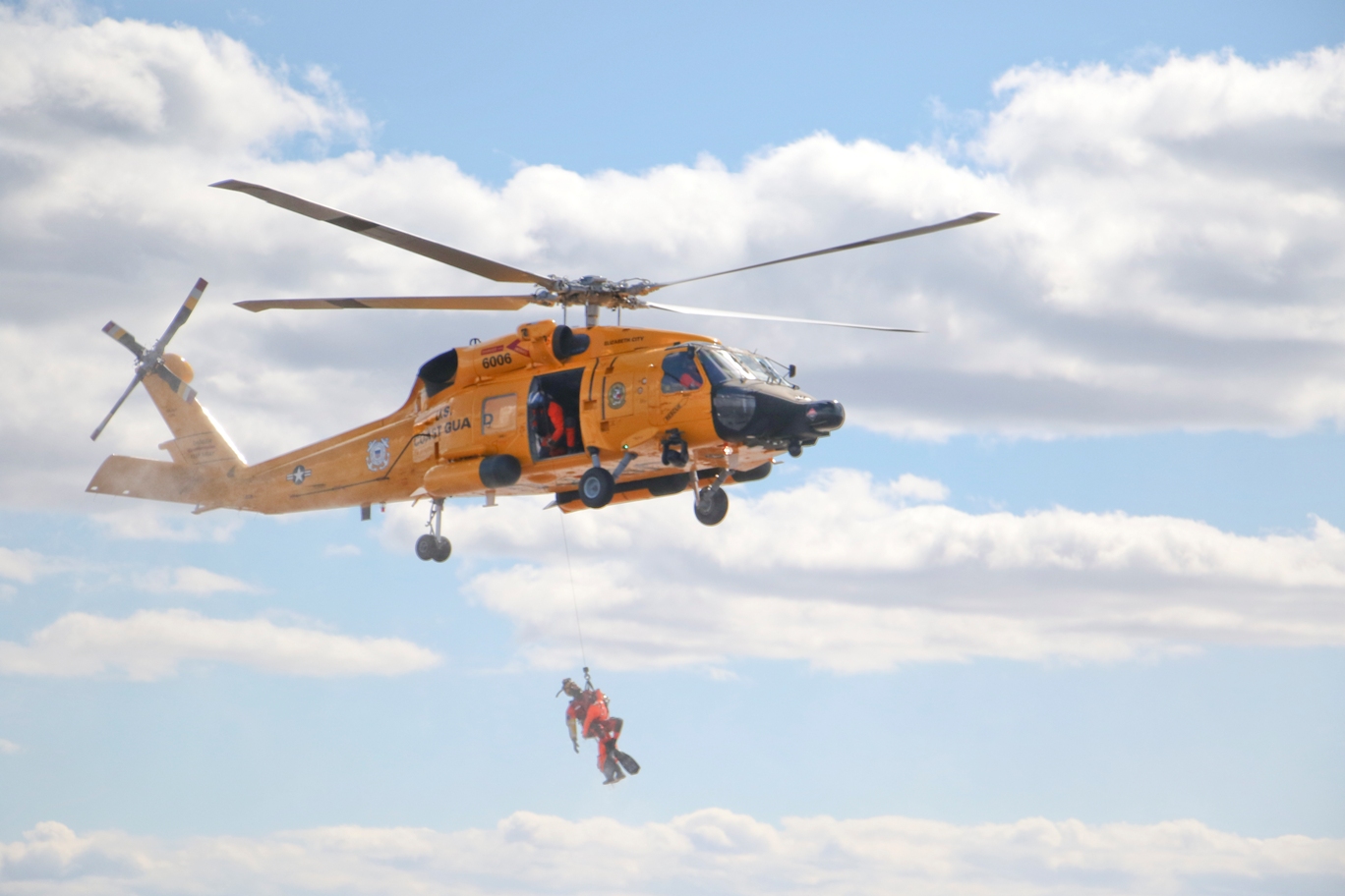 A search and rescue demonstration with a U.S. Coast Guard helicopter in retro color scheme to celebrate the USCG aviation centennial. (USCG photo/Lt. Cmdr. Krystyn Pecora)