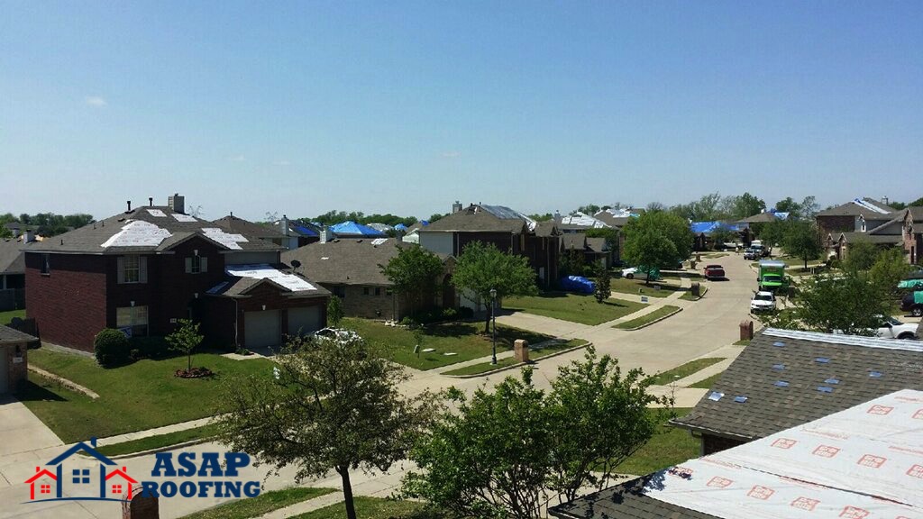 The ASAP Roofing team covers up a saturated hail damaged street in this image.
