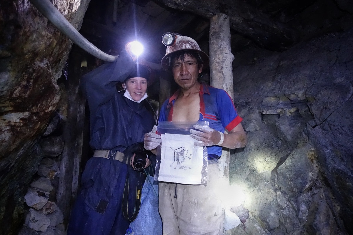 Johnson shares an embroidered piece with worker Ricky Martin in the Cerro Rico Mine in Potosi, Bolivia