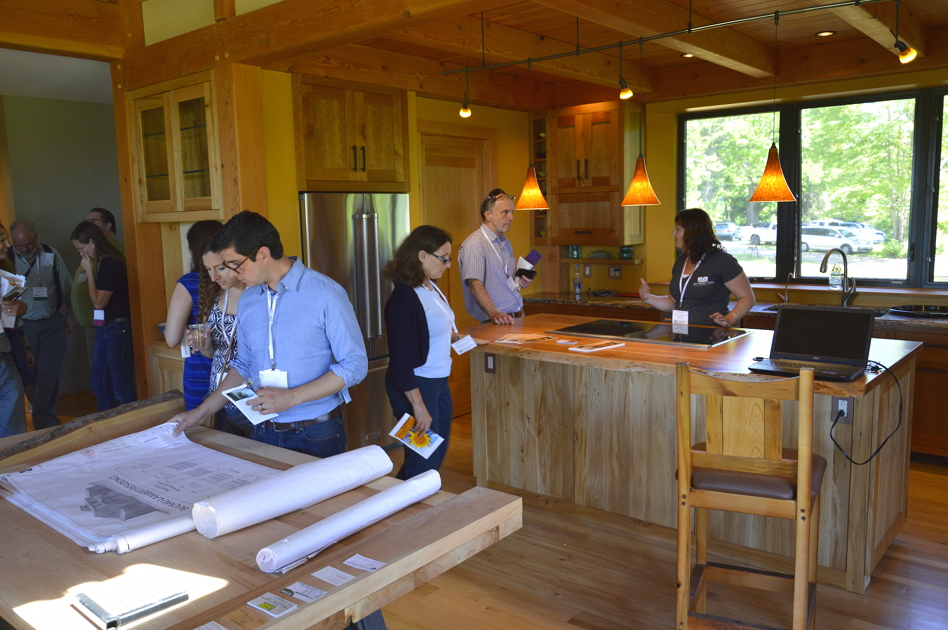 During the NESEA Pro Tour, participants looked at blueprints for the CreekSide net zero house. Custom cabinetry by NEWwoodworks can be seen in the background.