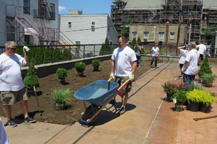A team of volunteers from Citrin Cooperman work to beautify the main courtyard at Eva’s Village.