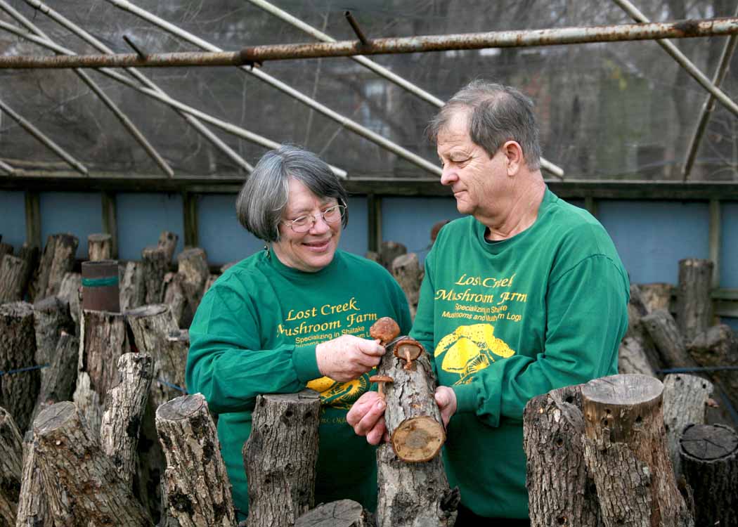 Sandra and Douglass Williams of Lost Creek Mushroom Farm with Shiitake logs