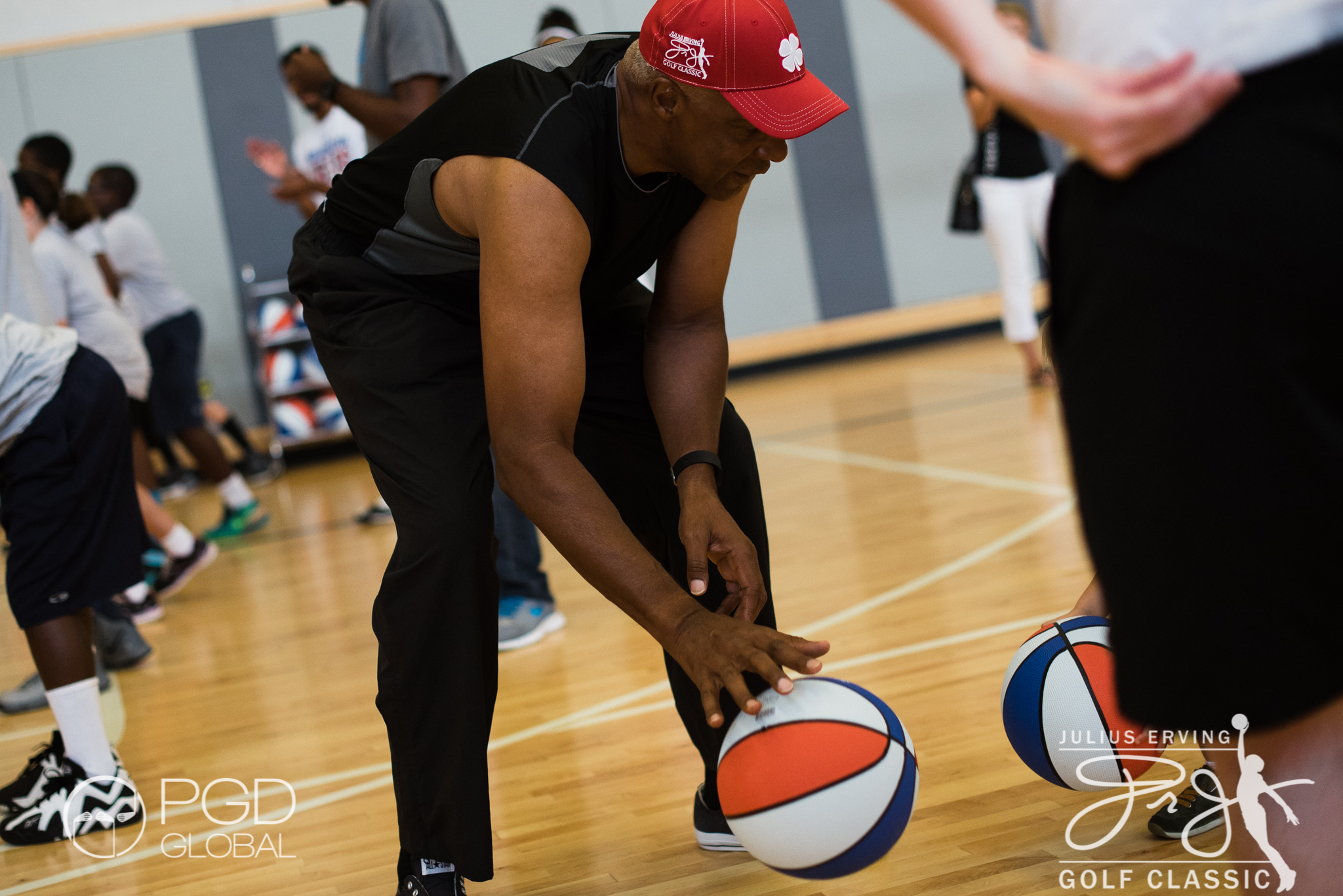 Dr. J dribbles the ABA style balls that were gifted to youth participants by Grab A Ball & Play Foundation