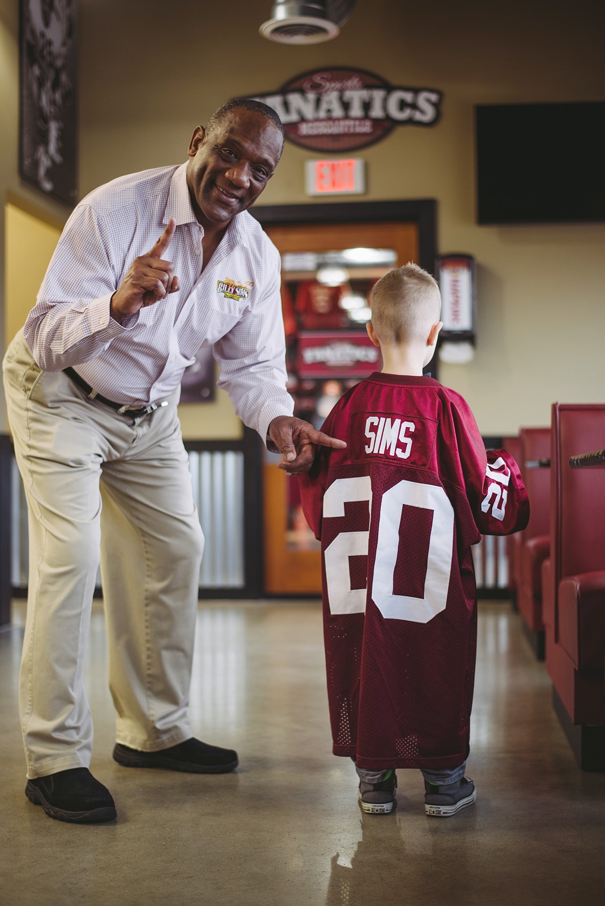 Billy Sims with boy with jersey