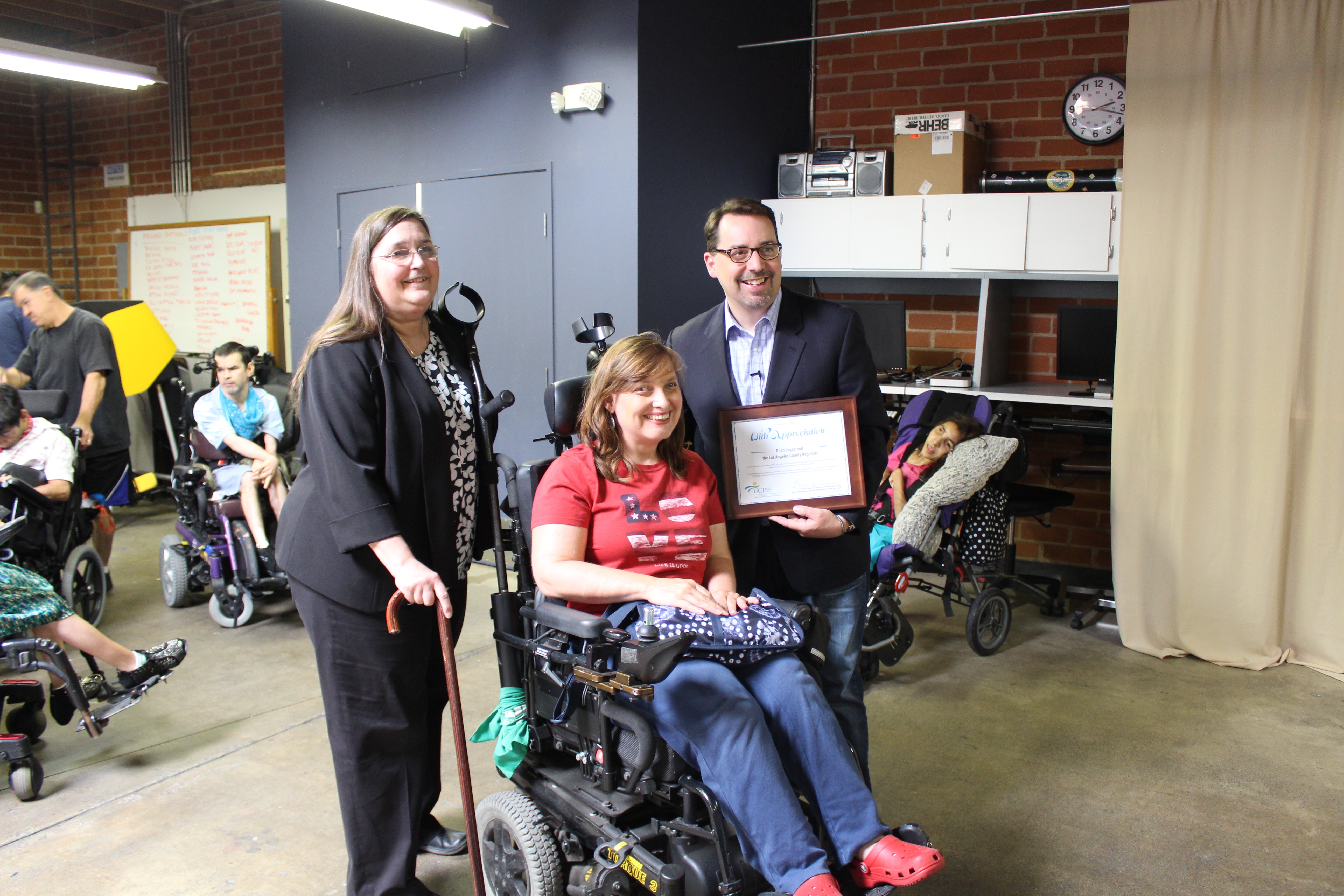 UCPLA Client Rights Advocate Terri Lantz (left) poses with LA County Registrar Recorder Dean Logan (right) and a self-advocate at UCPLA's Washington Place Adult Day Program.