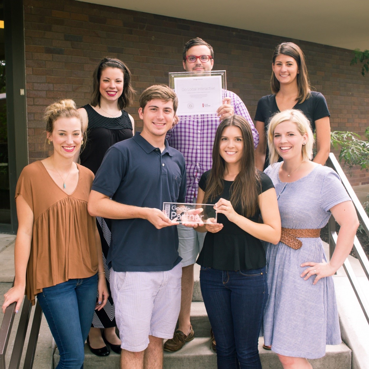 AdWords certified Go Local Interactive employees pose with their Google Premier Partner award.