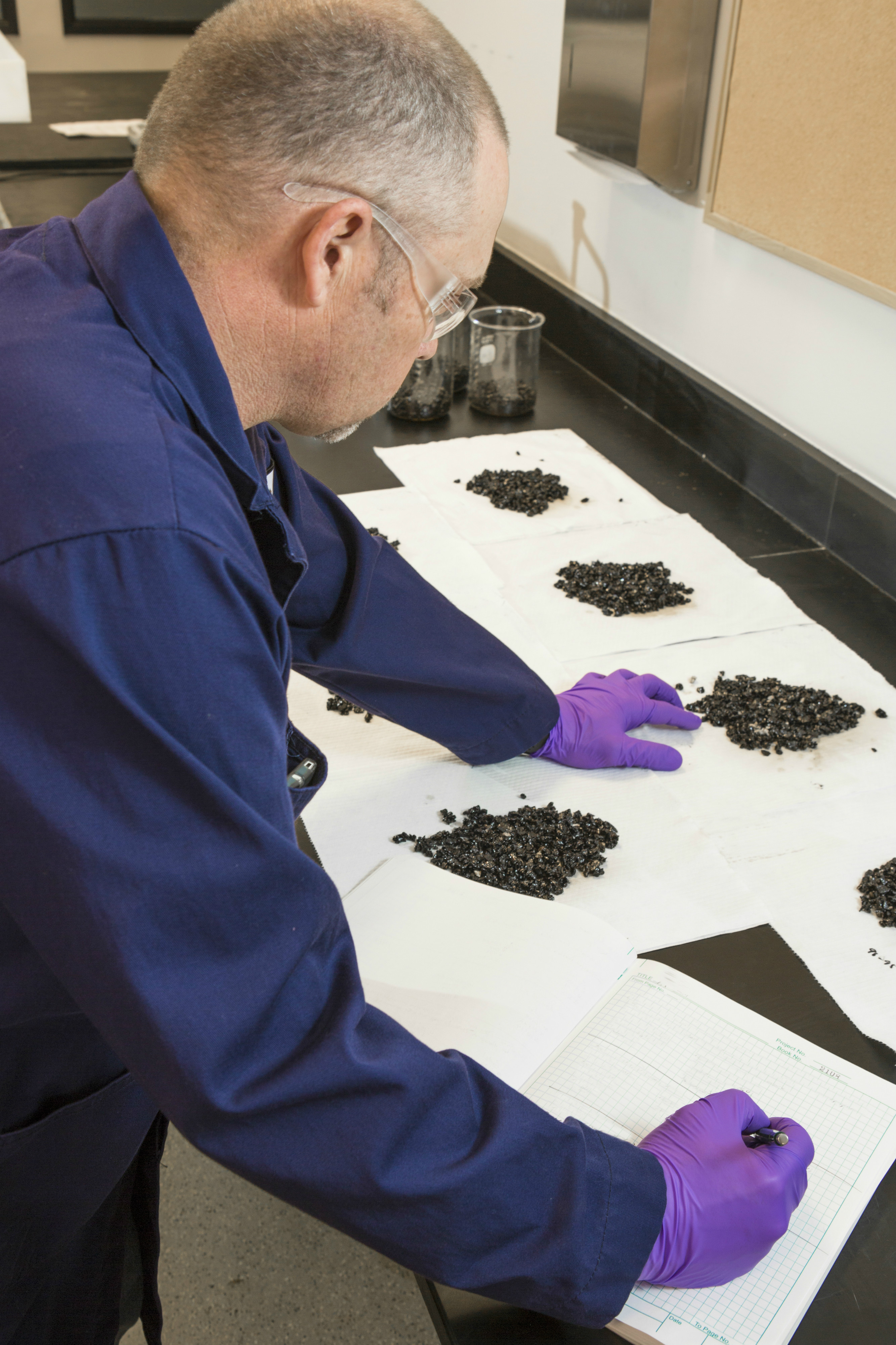 Road Science lab technician checking the coating and stripping of cold mix samples made with ColdGrip IQ™.