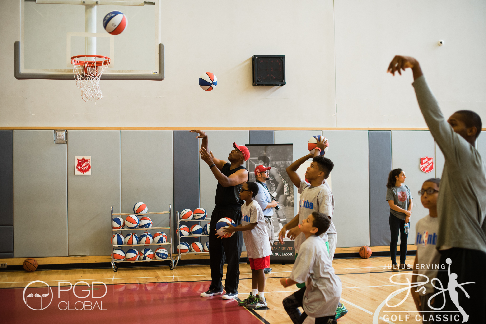 Julius Erving shoots hoops with the kids after they all received an ABA style basketball from Grab A Ball & Play